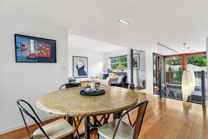 A modern interior with a round dining table, chairs, a sofa, and a large window. - FERNWEH - THE VINTAGE HOLIDAY HOUSES (Rothbury)