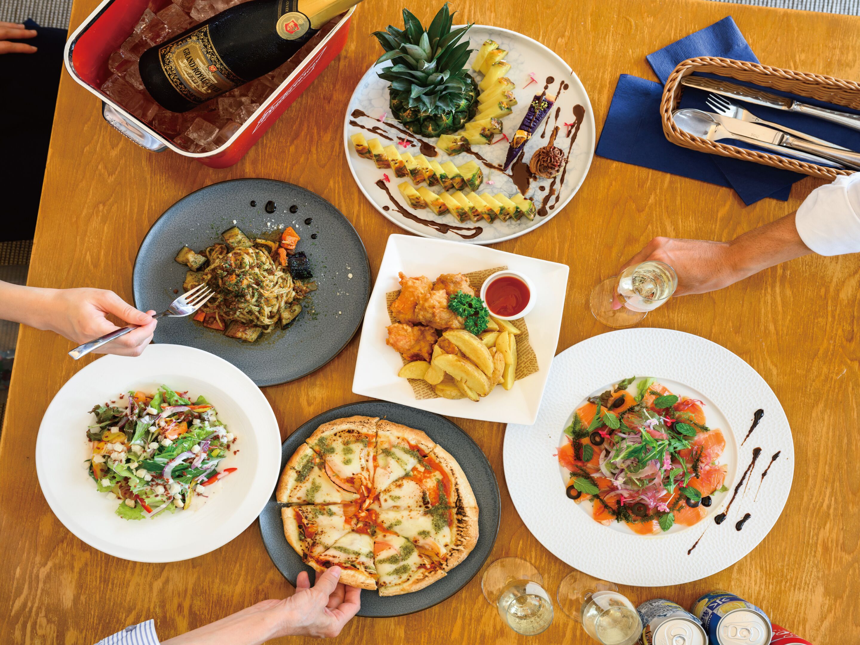 A table with various dishes, including pizza, salad, and a dessert with a pineapple.