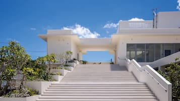 A modern building with a staircase leading to a flat roof.