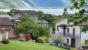 Un área residencial con casas, un lago y montañas al fondo.