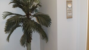A corner room with a palm tree, a light blue wall, and two signs: one saying "Beach mode" and another with "RELAX ENJOY". - Updated & short walk to downtown Charlevoix! (Charlevoix)