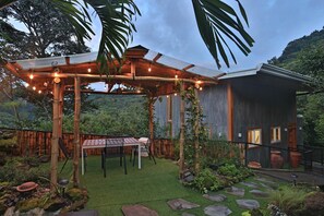Escape to a serene garden oasis with a pergola, lawn, and seating area.