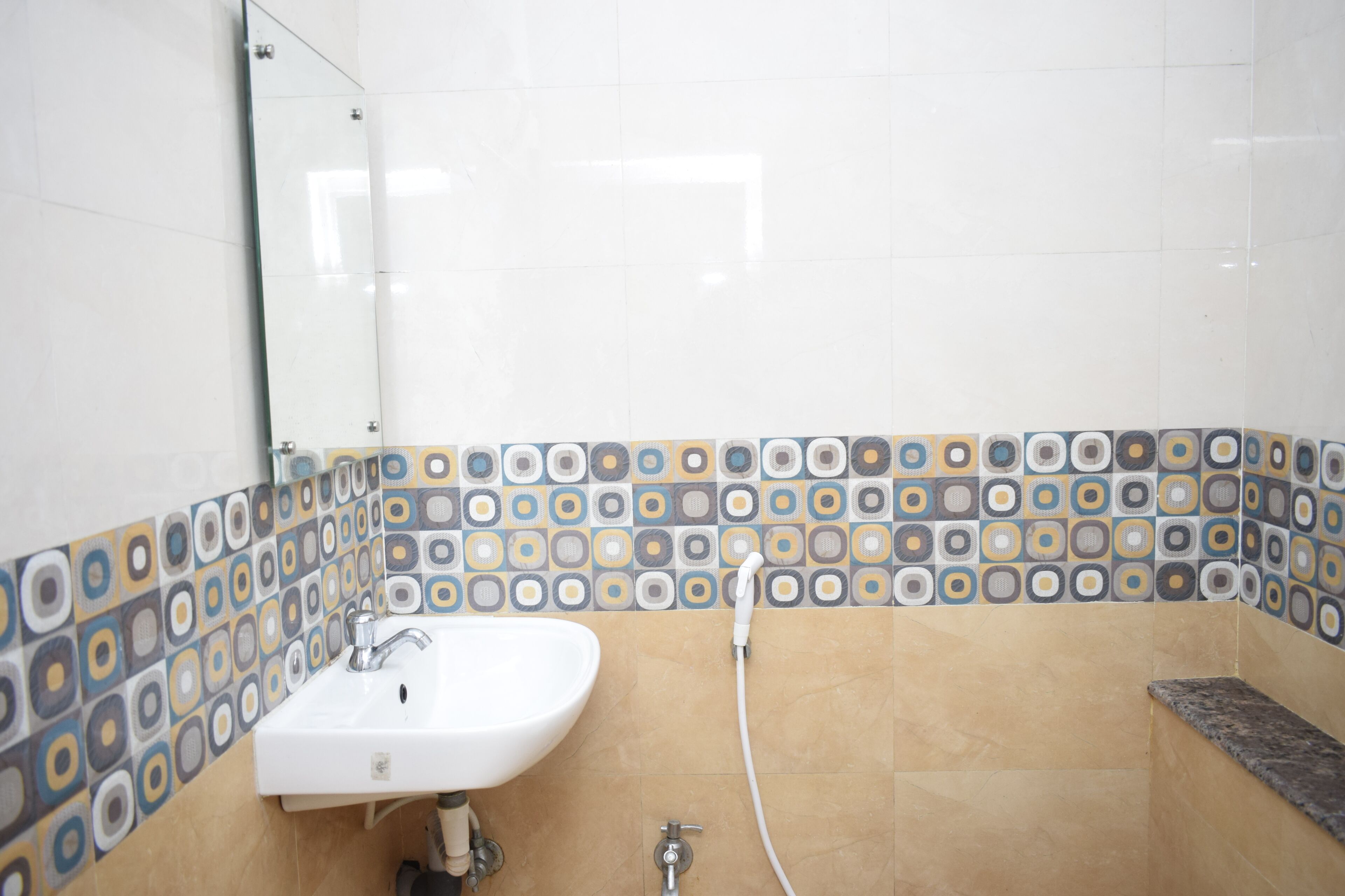 A bathroom with a white sink, a mirror, and a shower area.