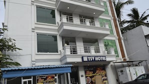 Un immeuble à plusieurs étages, avec une enseigne indiquant « TSV Hotel » au rez-de-chaussée.