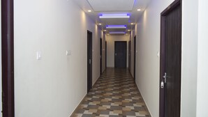 Un couloir doté d’un revêtement de sol à motifs, de portes des deux côtés et d’un éclairage encastré.