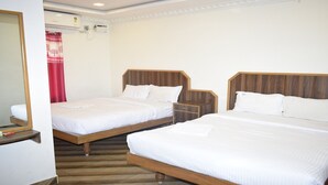 Une chambre d’hôtel avec deux lits en bois, du linge de lit blanc, une table de chevet en bois et un miroir.