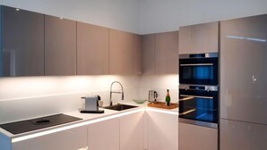 Una cocina moderna con horno integrado, lavaplatos y cafetera.