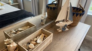 A wooden dresser with two open drawers containing seashells, a small sailboat model, and two woven baskets. - Brand New Luxury Property at The Peninsula- Double Master Sleeps 10 (Millsboro)