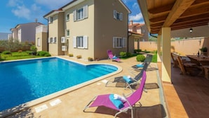 A two-story house with a swimming pool, outdoor seating, and a covered patio area. - Villa Zara by Interhome (Pula)