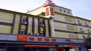 A hotel with a yellow facade, a prominent sign for 'home inn', and several smaller signs indicating various amenities and services. - Home Inn Beijing Communication University of China West Gate (Beijing)