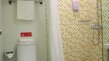 Un baño con ducha, inodoro y pared de azulejos.