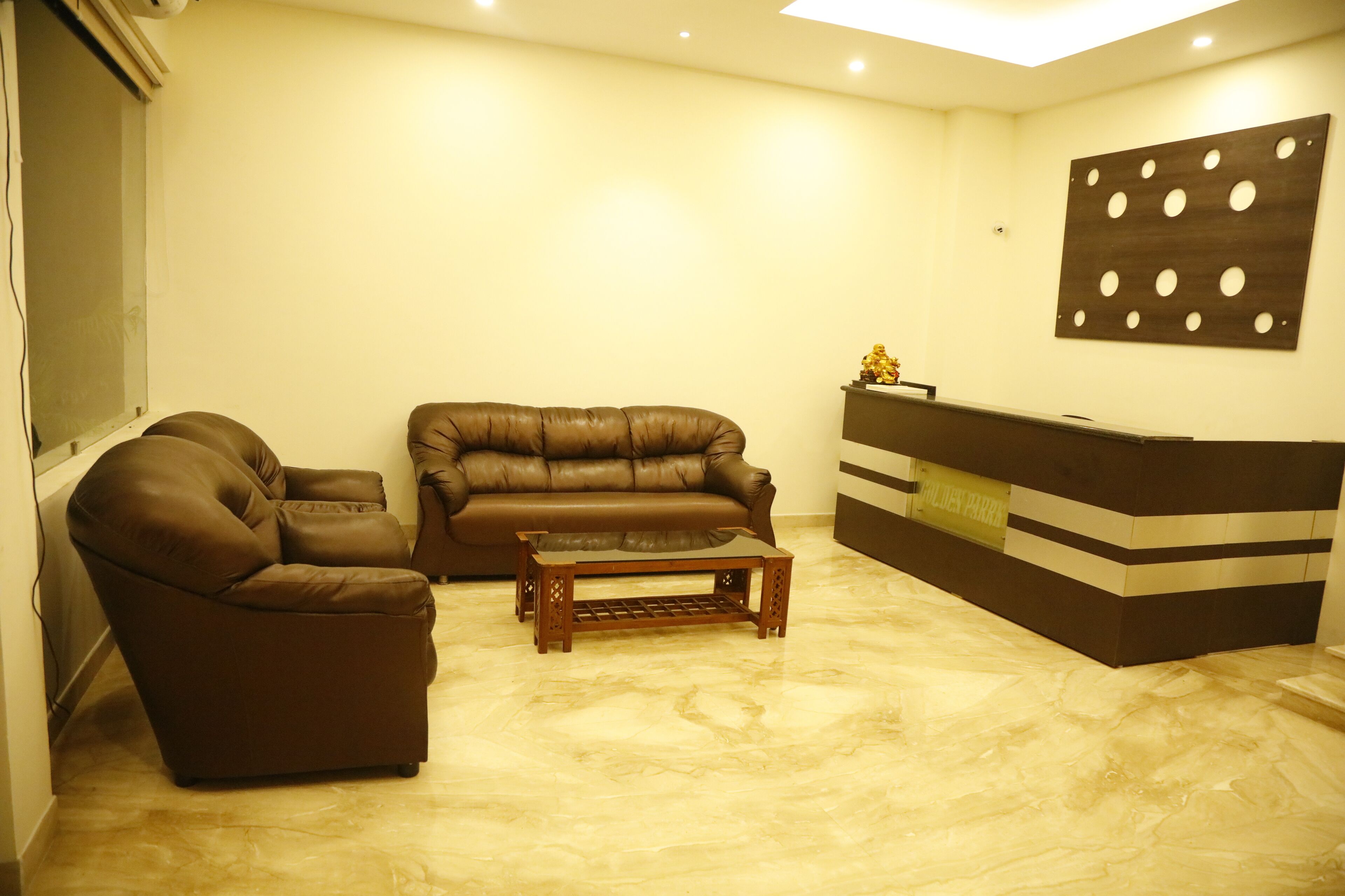 A living room with a brown leather sofa, a matching armchair, and a wooden coffee table.