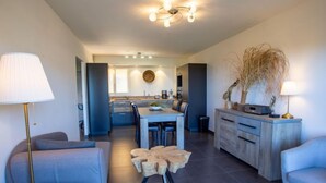 Ein modernes Wohnzimmer mit einer Couch, einem Couchtisch und einem Essbereich mit Stühlen und einem Tisch.