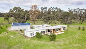 Una casa moderna con un panel solar, un garaje amplio y un césped cuidado.