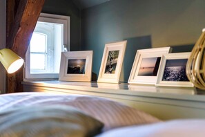 A bedroom with a bed, a nightstand, and a window with a view.