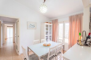 Un espace repas comprenant une table, des chaises, un buffet et un meuble à bouteilles.