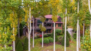 A multi-story house surrounded by trees.