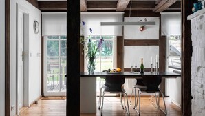 A modern kitchen with a central island, wooden beams, and large windows. - Pommernhaus Vorsee am Kiefernwald Kamin Boot - Thatched half-timbered house, fireplace (Ahlbeck)
