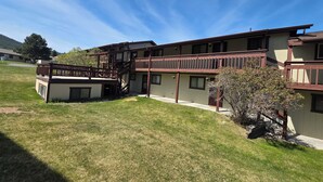 A multi-story building with a central staircase, balconies, and a small garden area. - Lee's Helena Hideout (Helena)