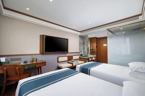 A hotel room with two beds, a desk, a television, and a bathroom with a glass shower enclosure. - Nostalgia S Hotel (Beijing)