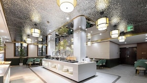 A modern hotel lobby with a central reception desk, seating area, and decorative ceiling. - Nostalgia S Hotel (Beijing)