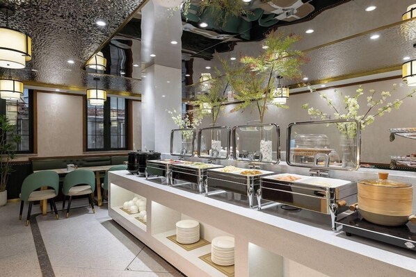 Un espace buffet doté de plusieurs points de service, un coin salon avec des chaises et un plafond décoratif.