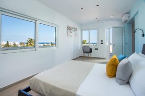 A bedroom with a bed, two windows, a chair, and a door leading to a balcony. - Faliraki Premium Hotel (Rhodes)