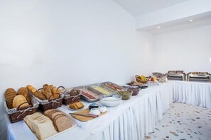A buffet table with various food items and bread. - Faliraki Premium Hotel (Rhodes)