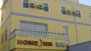 Un edificio amarillo con un letrero que dice "HOME NN" y un balcón.