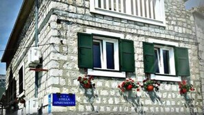 A stone building with a balcony and a sign reading "Stella Apartments". - Studio apartment by the sea (Kaštel Sućurac)