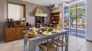 Un comedor con una mesa preparada para cuatro, un armario de madera, un ventilador y vistas al exterior.