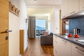 Une cuisine moderne avec une porte en bois, un canapé et une vue sur un balcon.