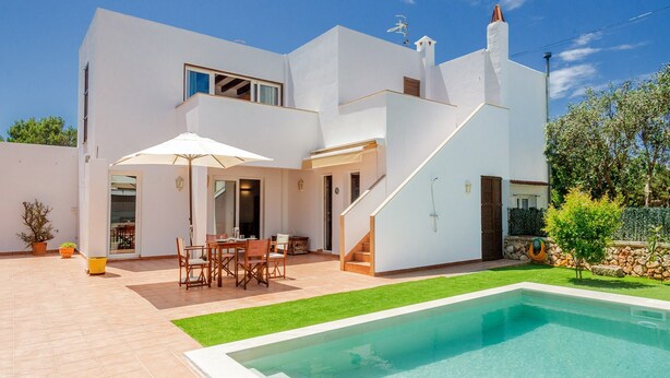 A modern two-story house with a swimming pool, outdoor seating, and a staircase.