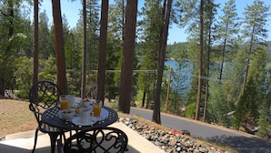 Ein Tisch mit Frühstücksangeboten und Blick auf einen von Bäumen umgebenen See.