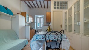 Cocina compacta con mesa, sillas y cama.