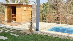 A wooden cabin with a small porch and a pool. - 2 Zimmer FeWo mit Außenpool und Sauna (Sulzfeld am Main)