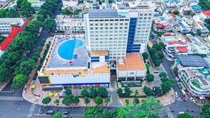 A hotel with a rooftop pool, a large building with a blue facade, and a smaller adjacent building with a solar panel. - Elephants Hotel Buon Ma Thuot (Buon Ma Thuot)