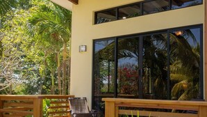 Un espace extérieur abrité, doté de bancs en bois et de plantes en pot.