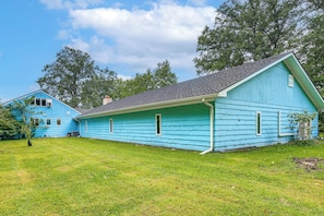 A two-story blue house with a sloped roof and a covered porch. - Featured on TV! Epic Indoor Pool • Sleeps 24 (Bridgman)