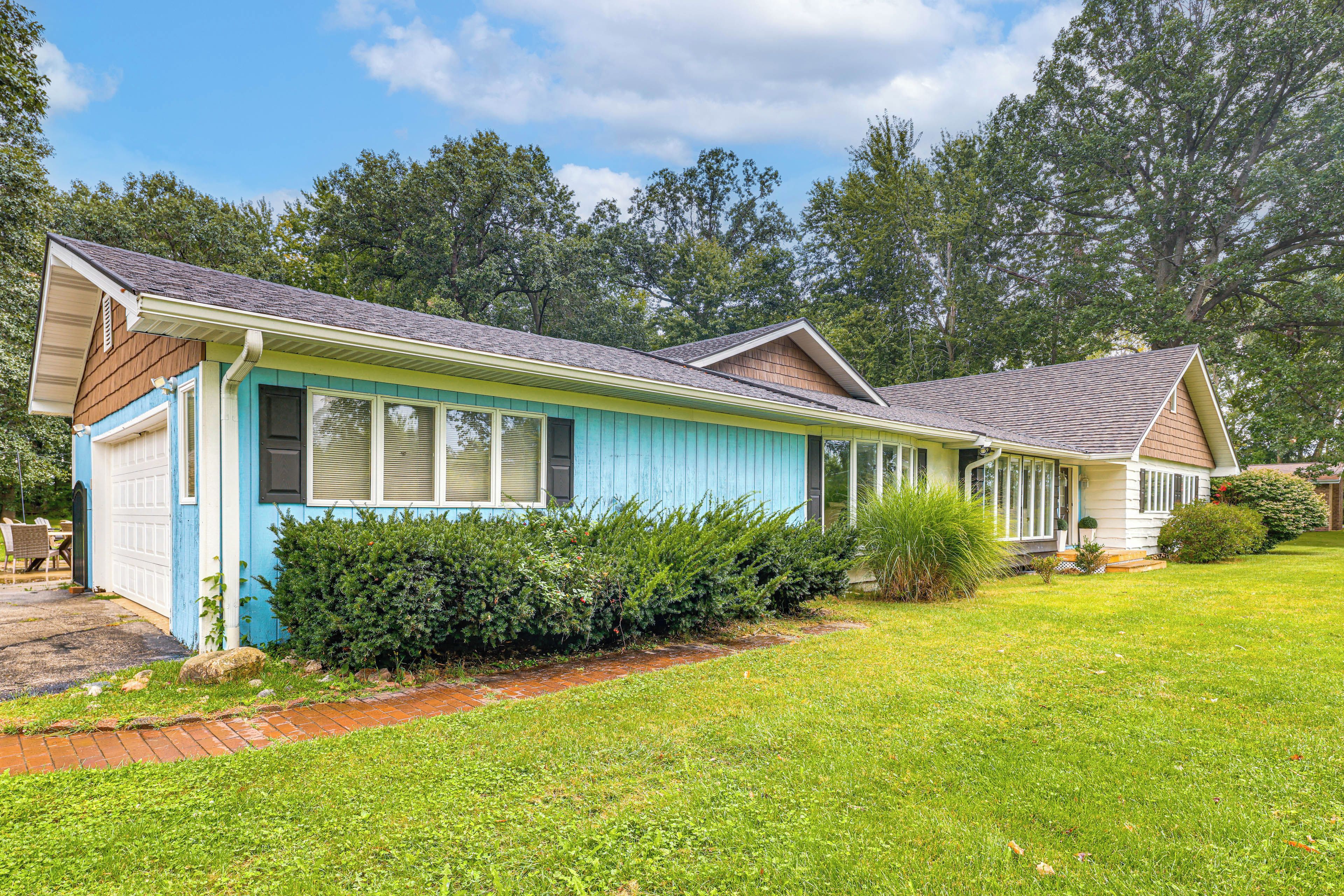 A two-story house with a front porch, a garage, and a well-maintained lawn.