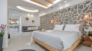 A modern bedroom with a stone wall, a wooden bed frame, and a built-in bench.