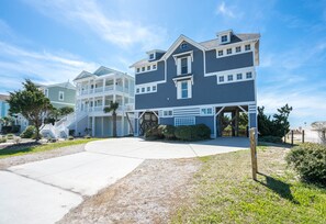 A two-story residential building with a covered front porch and a garage.