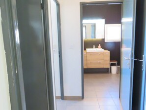 A bathroom with a sink, mirror, and a small stool.