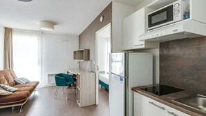 A modern apartment with a kitchenette, a sofa, a dining area, and a bathroom. - Les Glenans Toulouse (Toulouse)