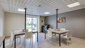A modern office space with two desks, chairs, a printer, and a view of a building through a glass door. - Les Glenans Toulouse (Toulouse)