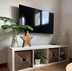 A modern living room with a flat-screen TV mounted on a white console.