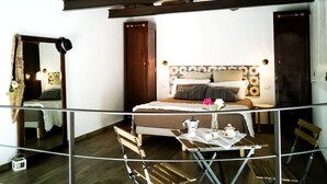 Une chambre à coucher avec un lit, une table de chevet avec une lampe, un miroir et une fenêtre.