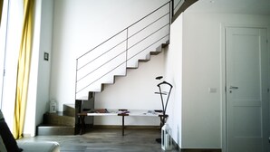Un vaste espace de vie comprenant un escalier, un banc et une table.