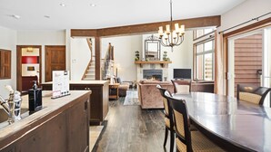 A spacious kitchen with a central island, a dining area with a large table, and a cozy living room with a fireplace.