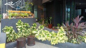A modern outdoor area with a geometric metal sculpture, a variety of potted plants, and a sign reading "AONANG DUONG". - Aonang Dugong (Krabi)